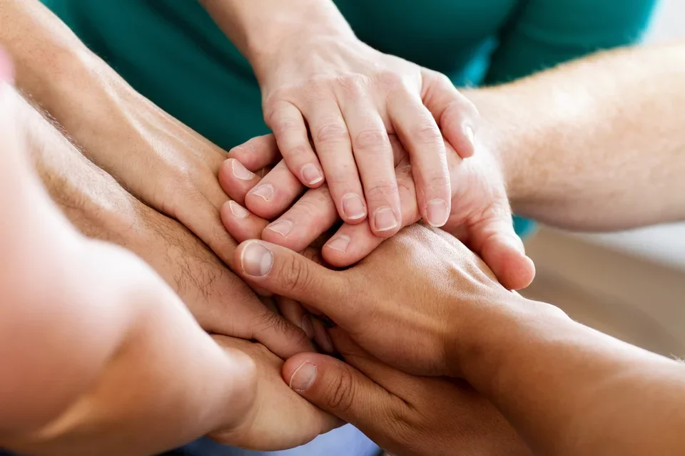 Group of people holding hands to show their unity and togetherness